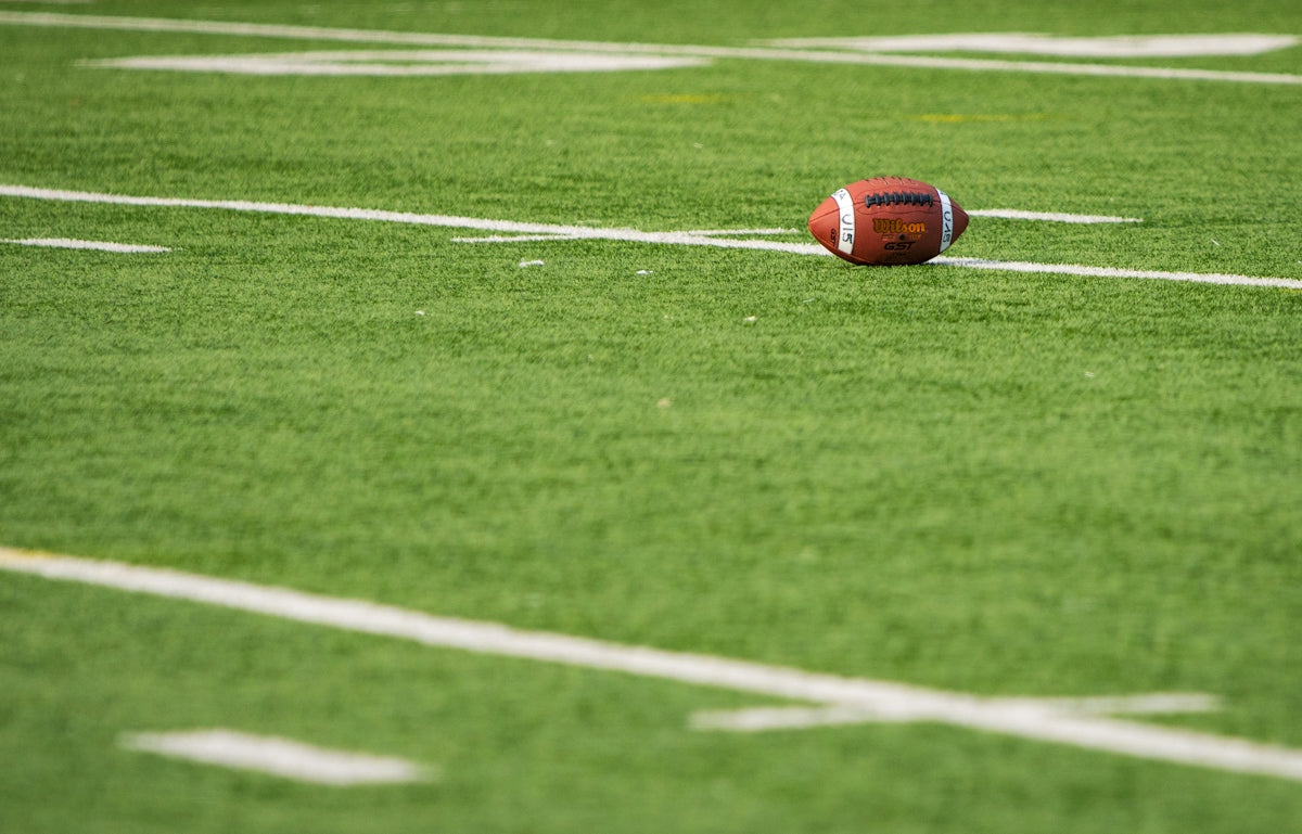 A football laying on a football field